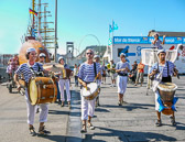 The musicians dressed as sailors are followed by a wooden submarine.