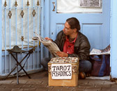 The Taro card reader in Galway takes some time off to read his newspaper instead of his cards.
