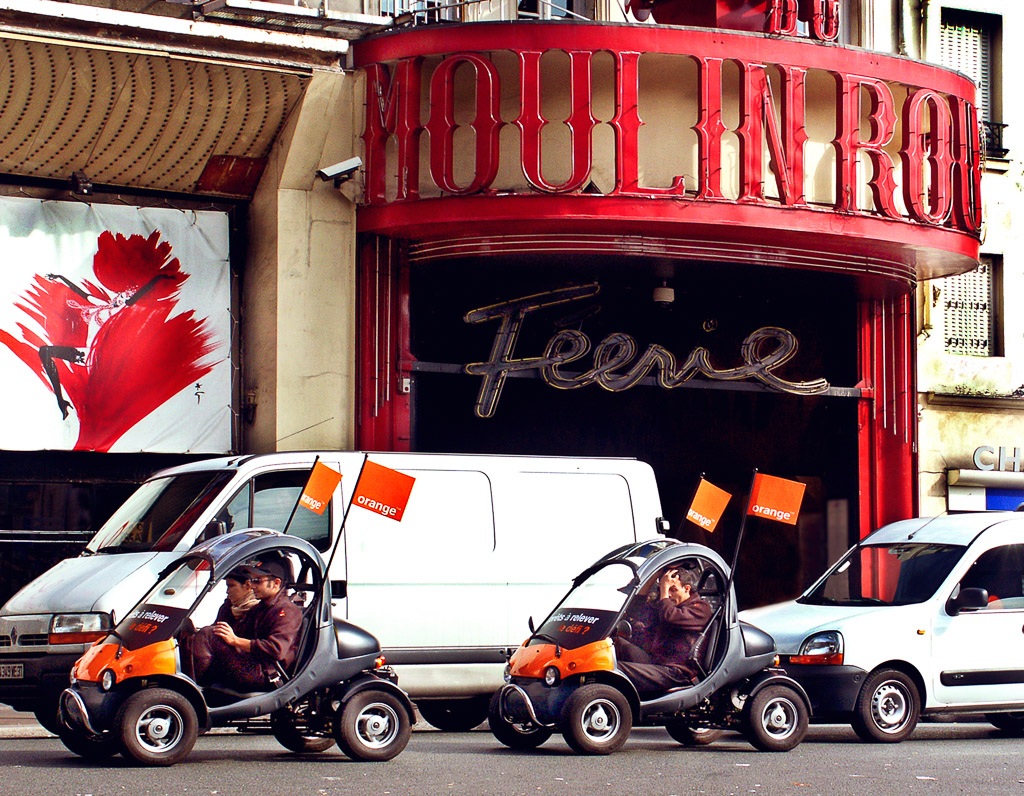 High gas prices inspire the design of cars like these driving past the Moulin Rouge.