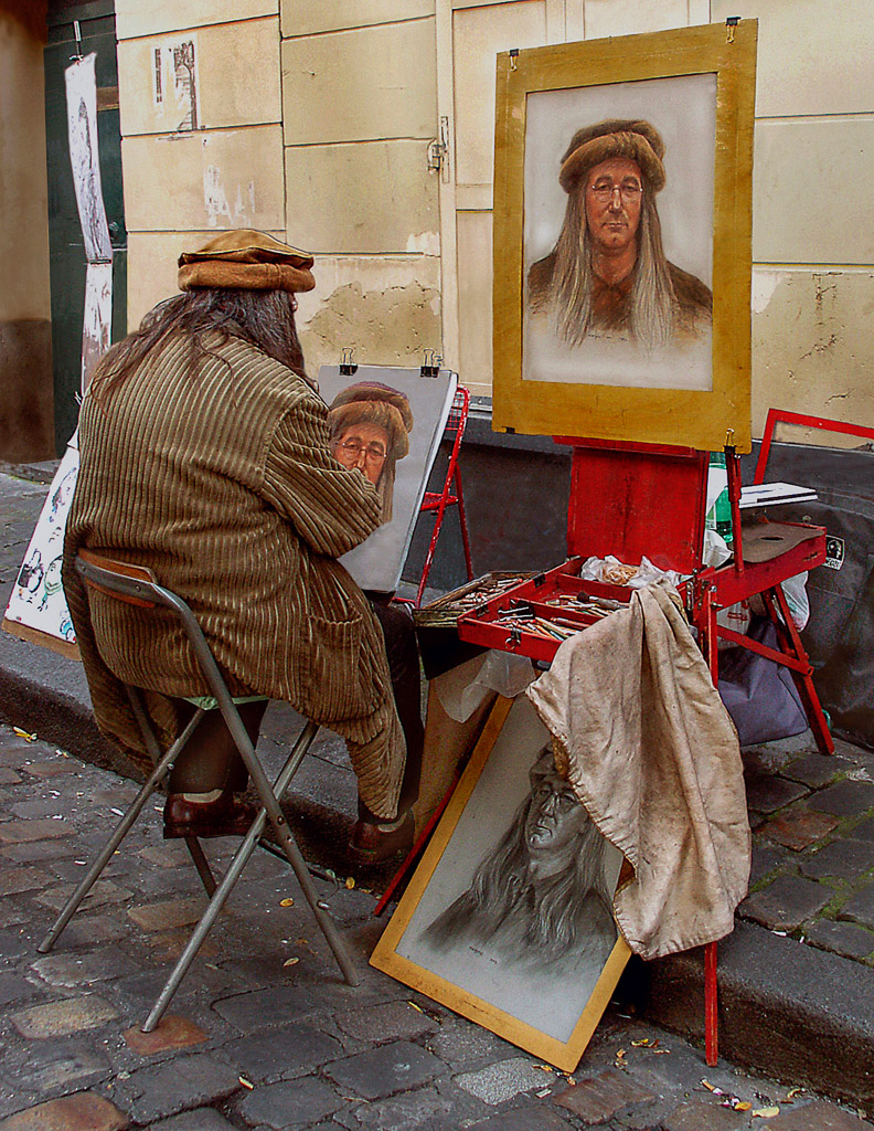 A self portrait artist hopes to sell his work at Place Tertre in Montmartre.